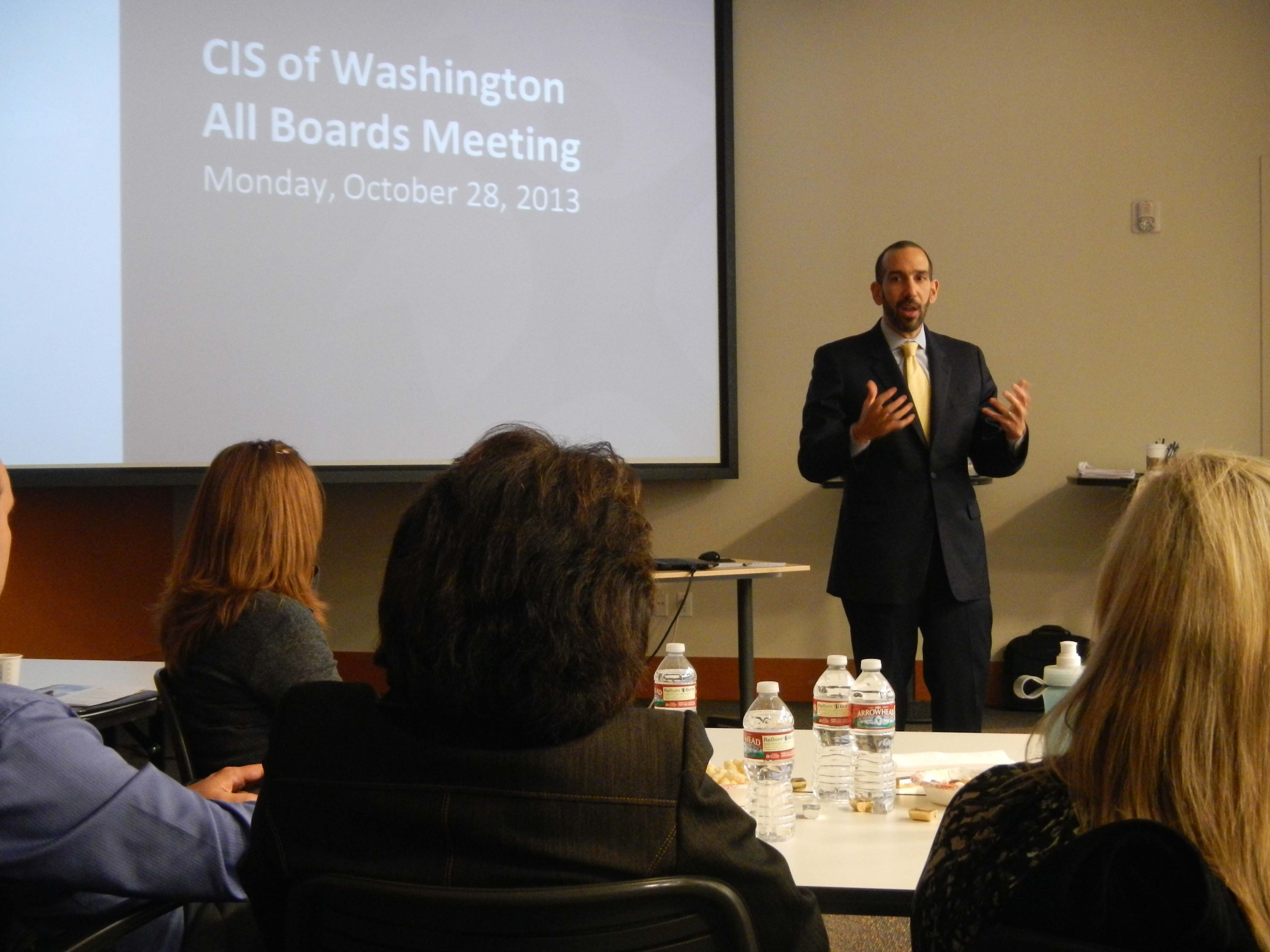 ���ϲ����� President Dan Cardinali stands before group giving slide presentation