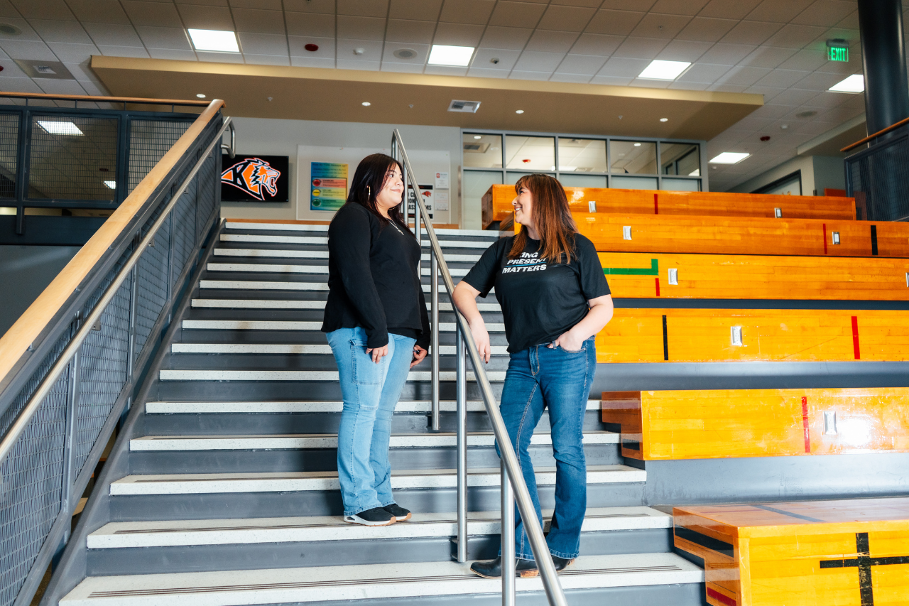 Support CIS with a donation, image shows two cis staff members next to school benches