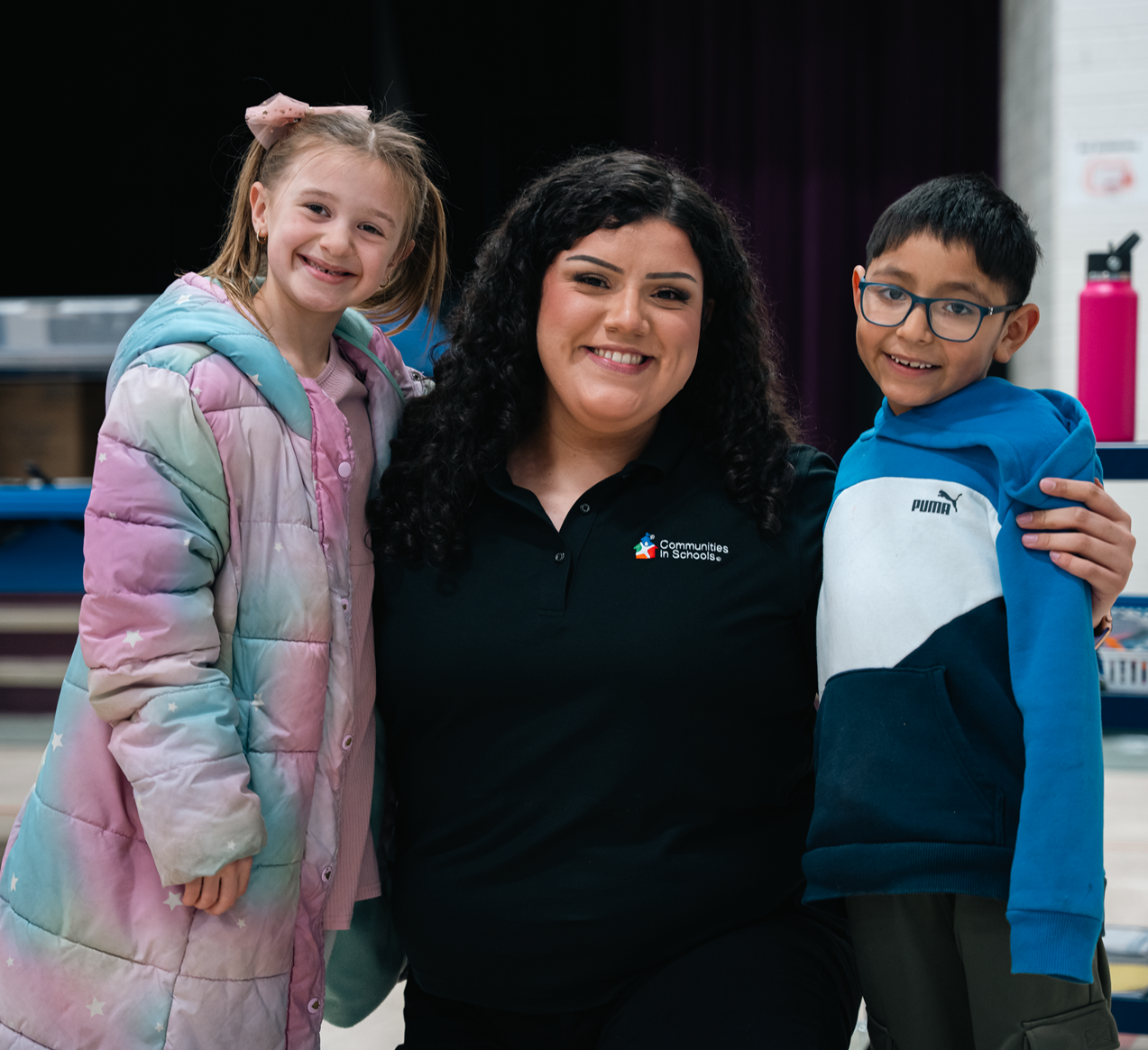 CIS WA Site coordinator with two young elementary school aged students looking at the camera and smiling