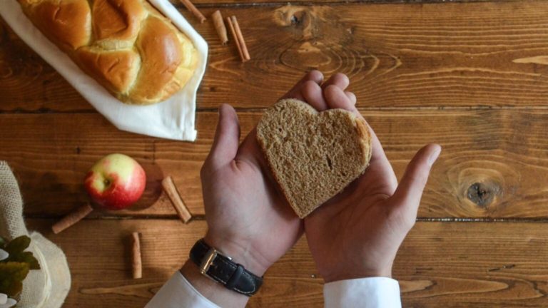 Hands holding bread shaped like a heart