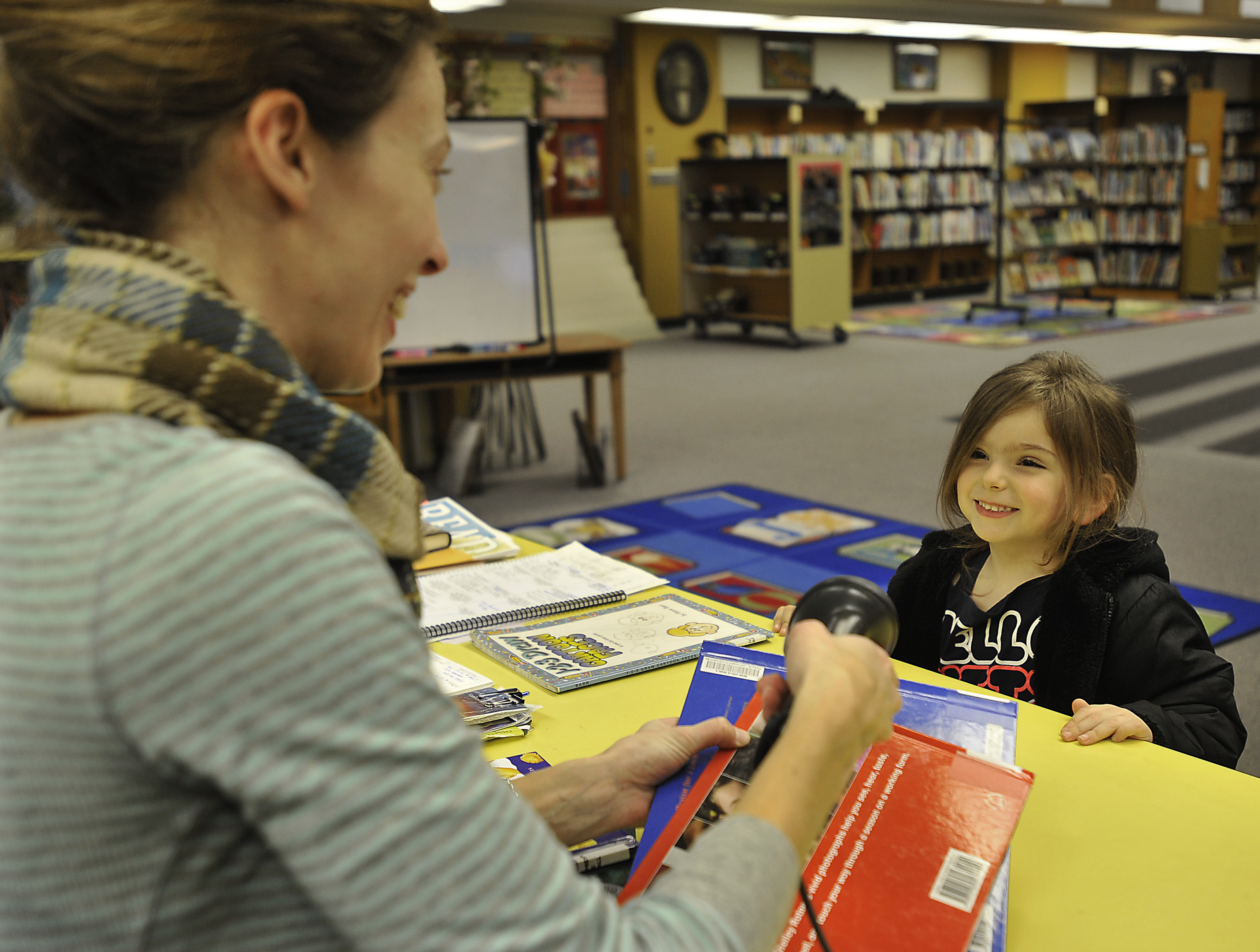 Foundation for Tacoma Students. Preschool student being read to by her relative. Photos by Russ Carmack