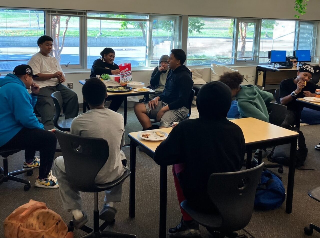 8 student sitting around and on desks for their first FREE YA MIND group meeting at Gray Middle School.
